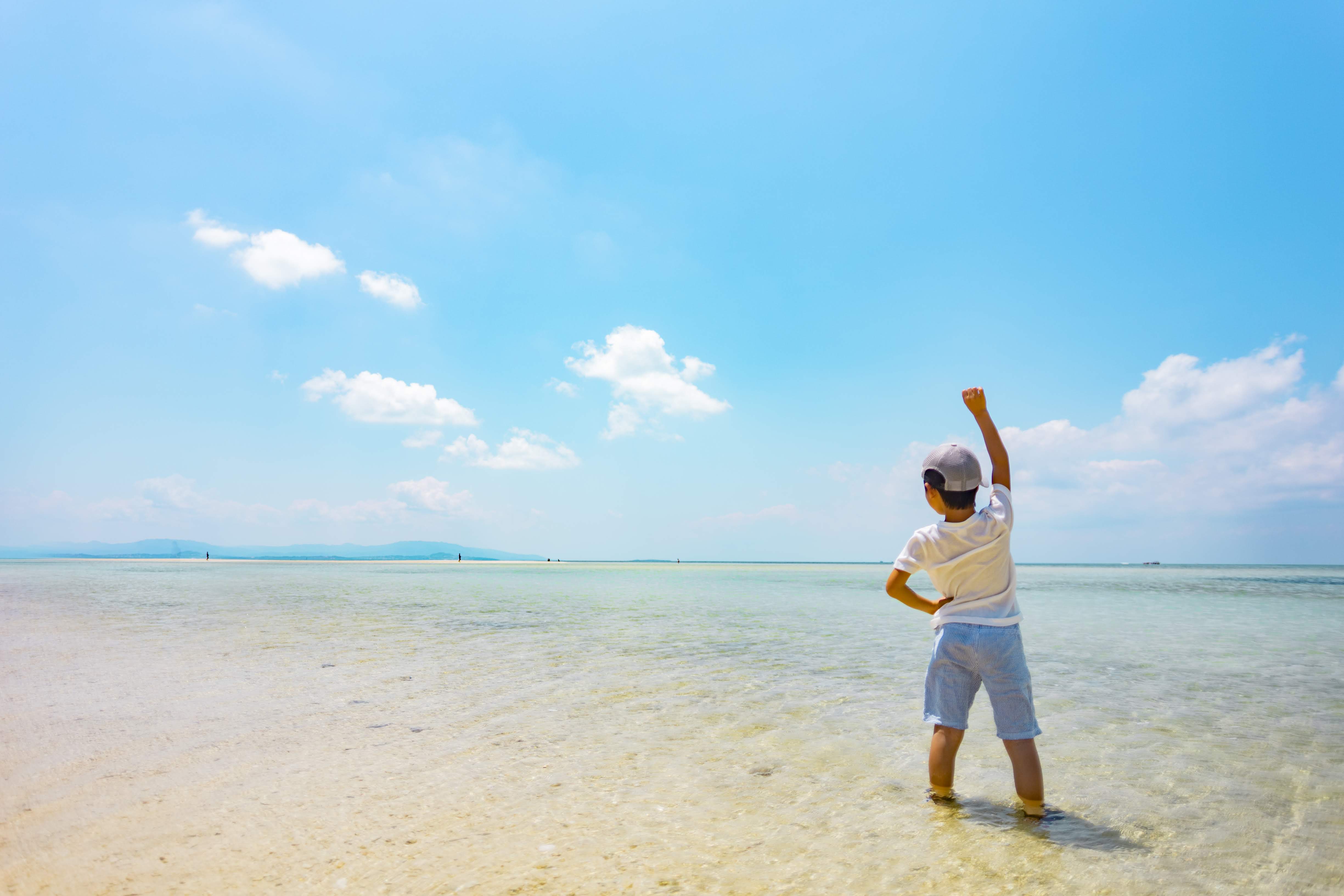 砂浜で手を上げる男の子