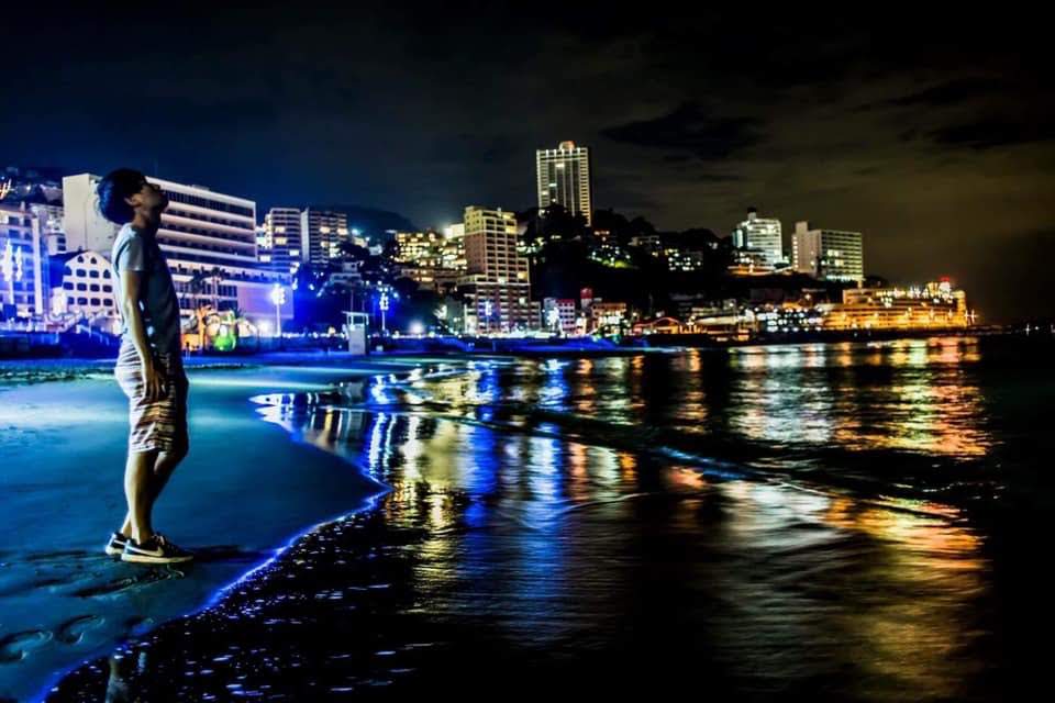 夜の海辺と街あかりの写真